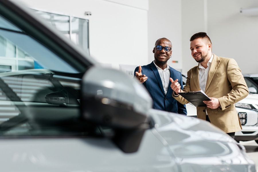 Zwei Mitarbeiter unterhalten sich über das Leasing eines Firmenwagens.