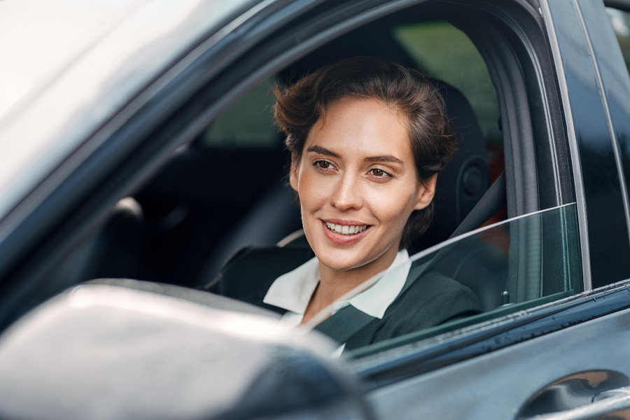Eine Dienstwagen Fahrerin sitzt im Auto und schaut prüfend vorne aus dem Auto. Die Carano Software zur UVV-Fahrerunterweisung unterstützt Unternehmen dabei, Sicherheitspflichten gesetzeskonform zu erfüllen. Durch digitale Unterweisungen, automatische Erinnerungen und einfache Dokumentation sorgt Carano für mehr Sicherheit und Effizienz im betrieblichen Fuhrparkmanagement.