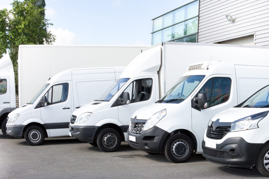 Eine Reihe moderner Transporter zeigt eine typische Unternehmensflotte. Das Motiv verdeutlicht, wie ein Flottenmanagementsystem Unternehmen bei effizienter Planung, digitaler Fuhrparksteuerung und nachhaltiger Fahrzeugnutzung unterstützt.