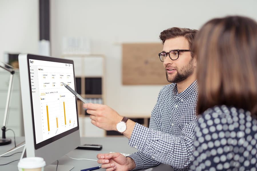 Zwei Personen analysieren Dashboard am Monitor. Fleet+ von Carano zeigt als zentrale Fuhrparkmanagement-Software eine skalierbare Plattform für ISS, die über 4.000 Fahrzeuge digital vernetzt, Prozesse automatisiert und fundierte Analysen für effizientes Flottenmanagement ermöglicht.