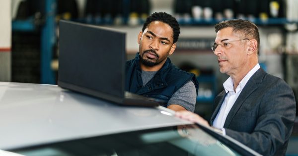 Two men stand at a vehicle and look at data on a laptop together. Digital evaluation and planning are key components of modern fleet management. Carano supports companies with software solutions for process optimization, cost reduction and legally compliant management of vehicle fleets - for more efficiency and transparency in everyday fleet management.