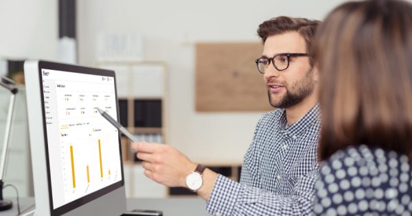 Ein Mitarbeiter erklärt einer Kollegin am Computer eine Auswertung zur Fuhrparkoptimierung mit der Software Fleet+. Die Grafik zeigt Balkendiagramme zur Fahrzeugnutzung. Carano unterstützt Unternehmen mit digitalen Lösungen für effizientes, nachhaltiges und transparentes Fuhrparkmanagement im Rahmen moderner Mobilitätsstrategien.